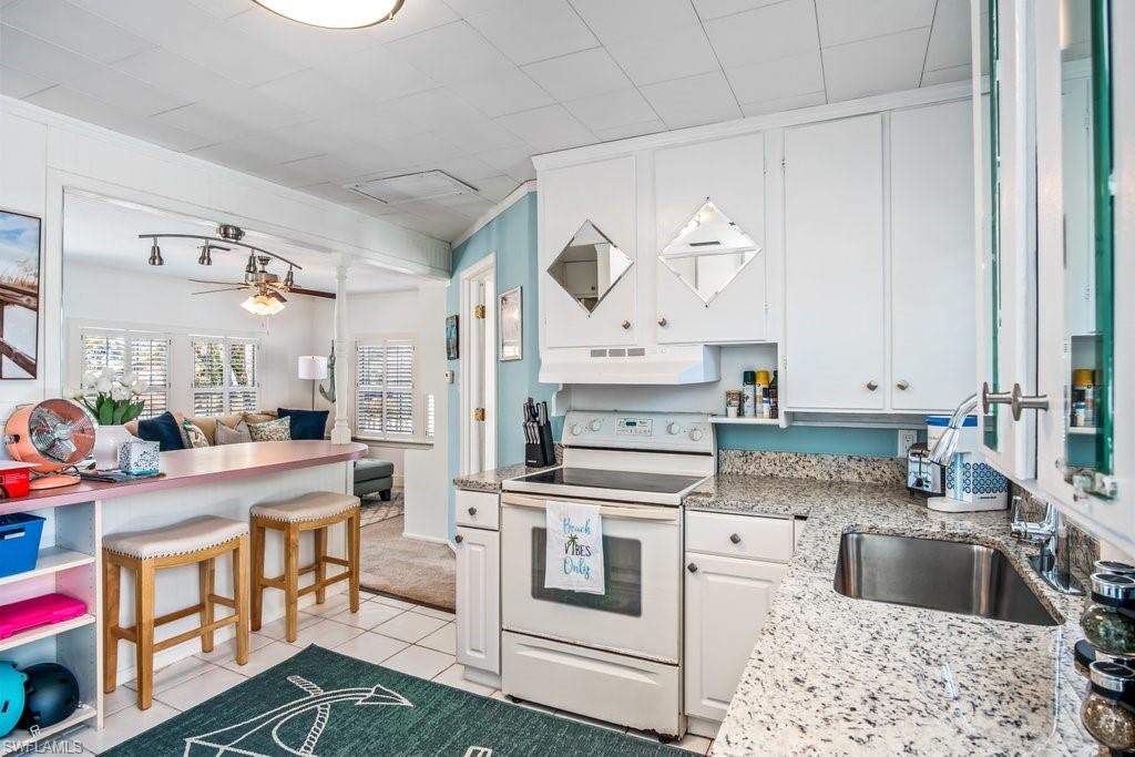 1012 Ridge Street Naples, FL 34103 - Photo 11 of 19 a kitchen with stainless steel appliances kitchen island granite countertop a sink stove and cabinets