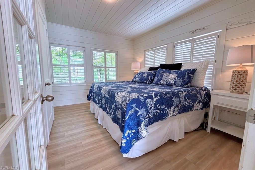 1012 Ridge Street Naples, FL 34103 - Photo 6 of 19 a bedroom with a bed next to a large window with wooden floor