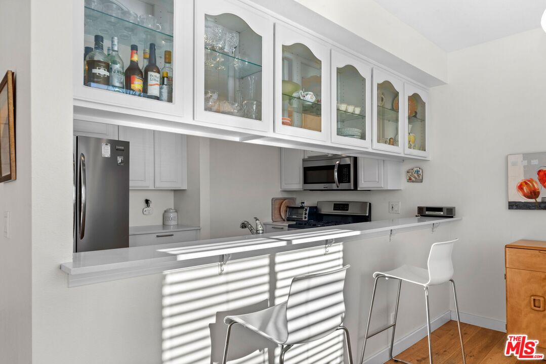11535 Rochester Avenue, Unit 302 Los Angeles, CA 90025 - Photo 12 of 28 a kitchen with stainless steel appliances kitchen island granite countertop a refrigerator and cabinets