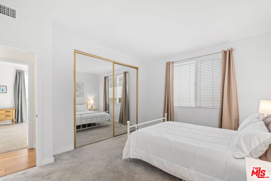 11535 Rochester Avenue, Unit 302 Los Angeles, CA 90025 - Photo 15 of 28 a bedroom with a large bed and a large mirror