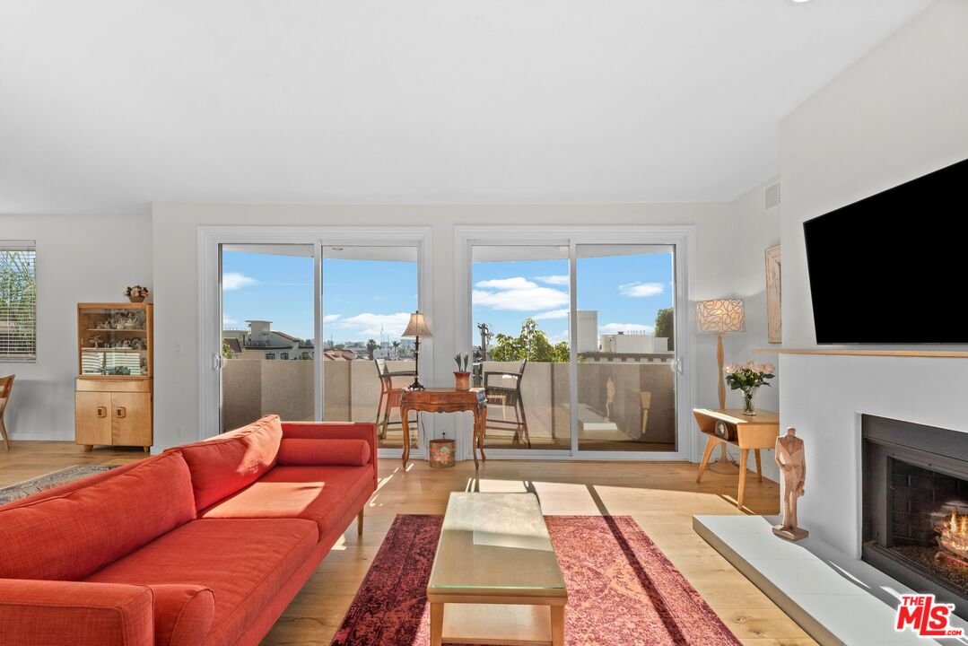 11535 Rochester Avenue, Unit 302 Los Angeles, CA 90025 - Photo 4 of 28 a living room with fireplace furniture and a flat screen tv