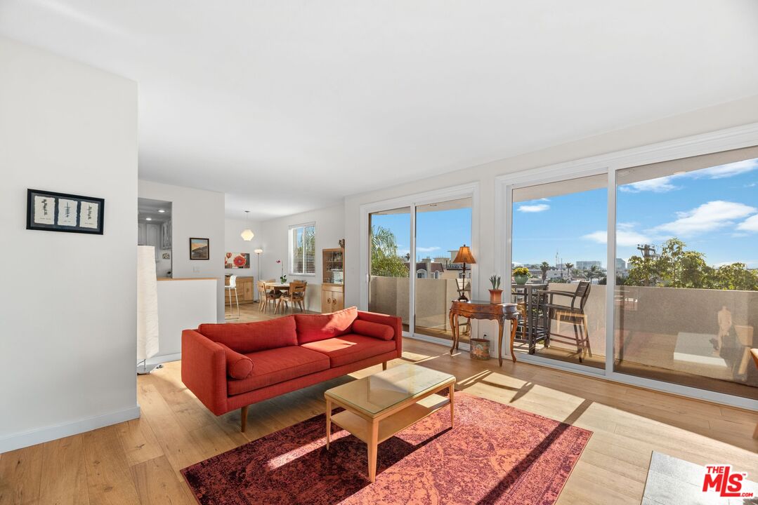 11535 Rochester Avenue, Unit 302 Los Angeles, CA 90025 - Photo 5 of 28 a living room with furniture a rug and a floor to ceiling window