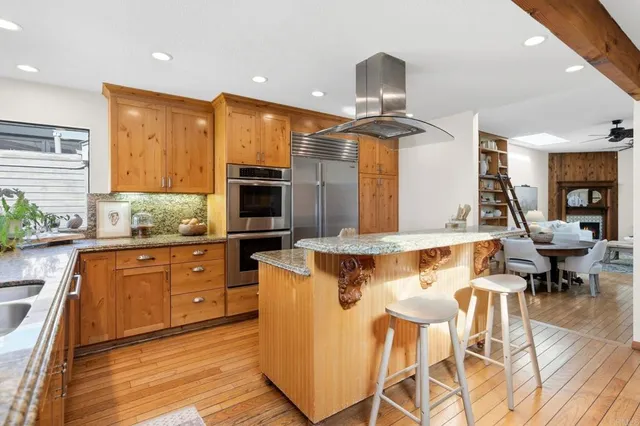 a living room with furniture large window and wooden floor