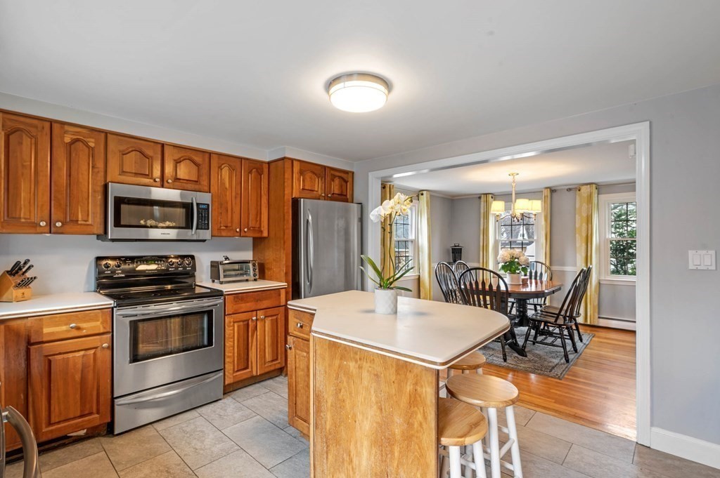 12 Pitman Road Marblehead, MA 01945 - Photo 10 of 28 a kitchen with stainless steel appliances granite countertop a stove top oven a sink dishwasher a dining table and chairs with wooden floor