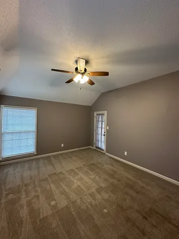 a view of a room with a ceiling fan and window