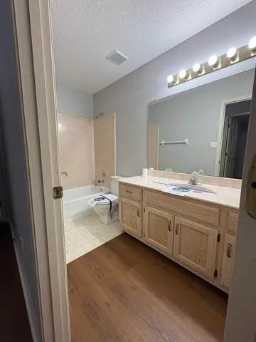 an empty room with ceiling fan and windows