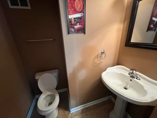 a bathroom with a toilet a sink and a mirror