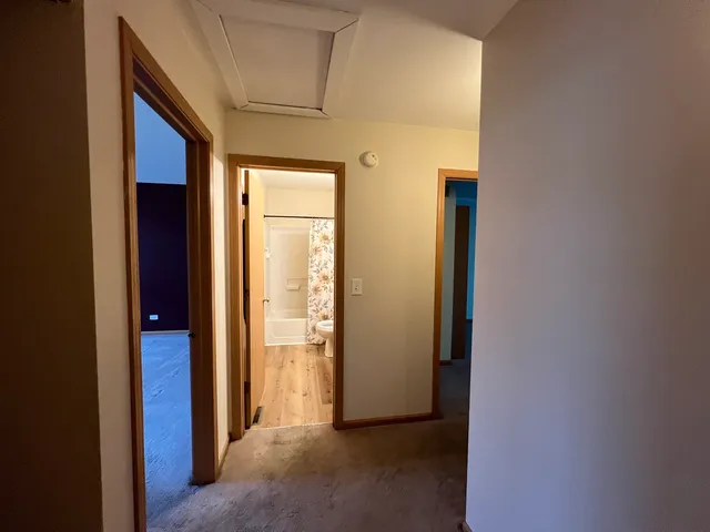 a view of a hallway with wooden shelves