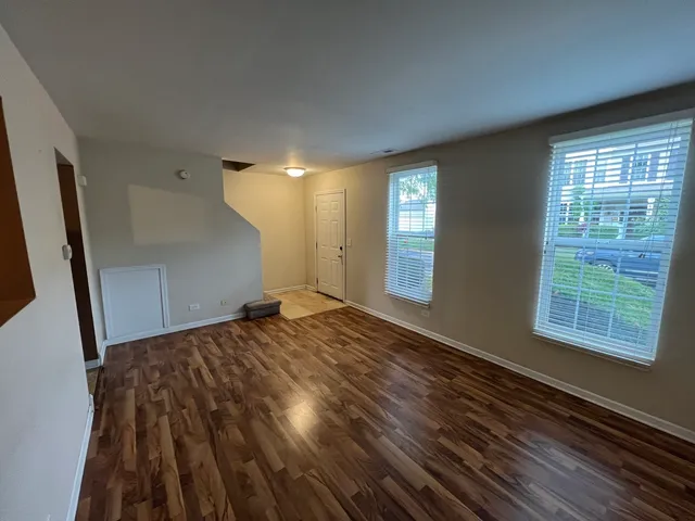 a view of a room with wooden floor and windows