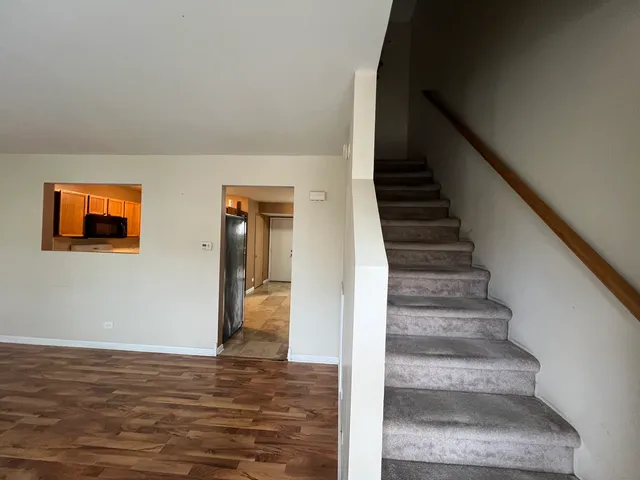 a view of a hallway with wooden floor and staircase