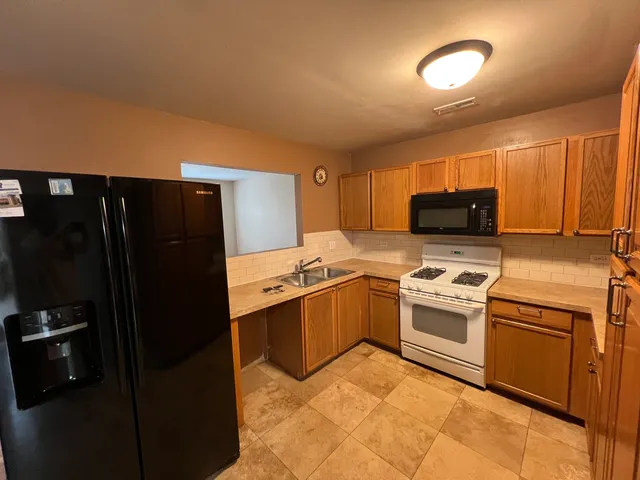 a kitchen with stainless steel appliances granite countertop a refrigerator stove and sink