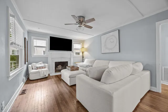 a living room with furniture a flat screen tv and a fireplace