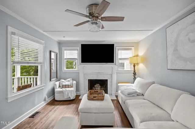 a living room with furniture a fireplace and a flat screen tv