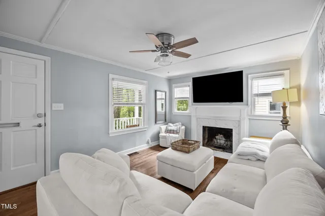 a living room with furniture a fireplace and a flat screen tv
