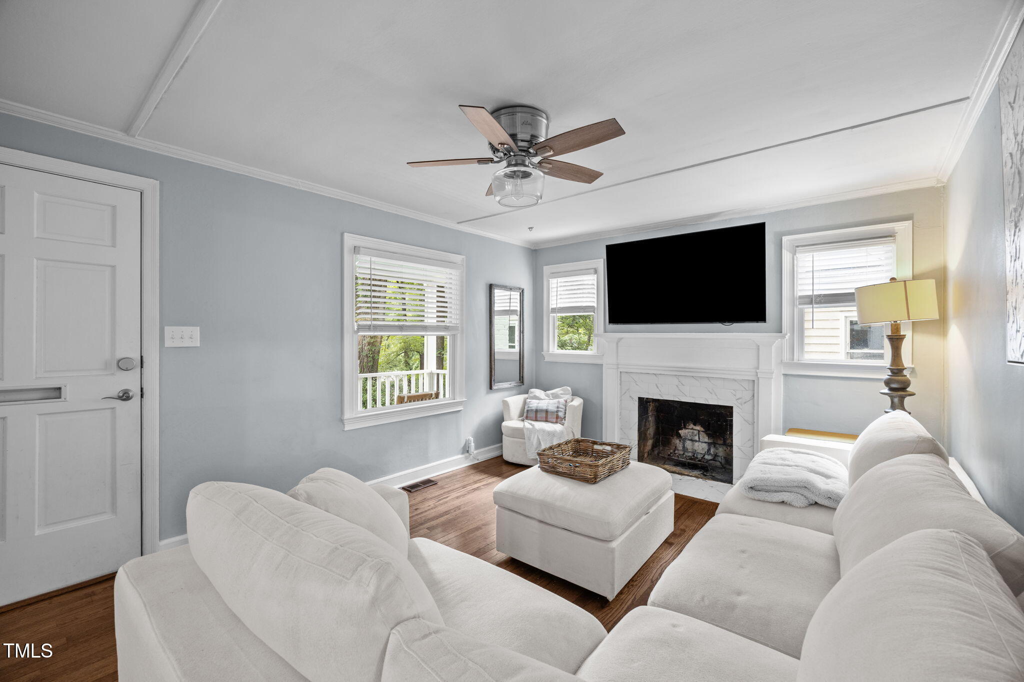 2721 Cartier Drive Raleigh, NC 27608 - Photo 16 of 44 a living room with furniture a fireplace and a flat screen tv