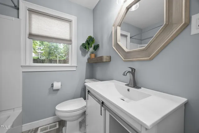 a bathroom with a sink a mirror and a toilet