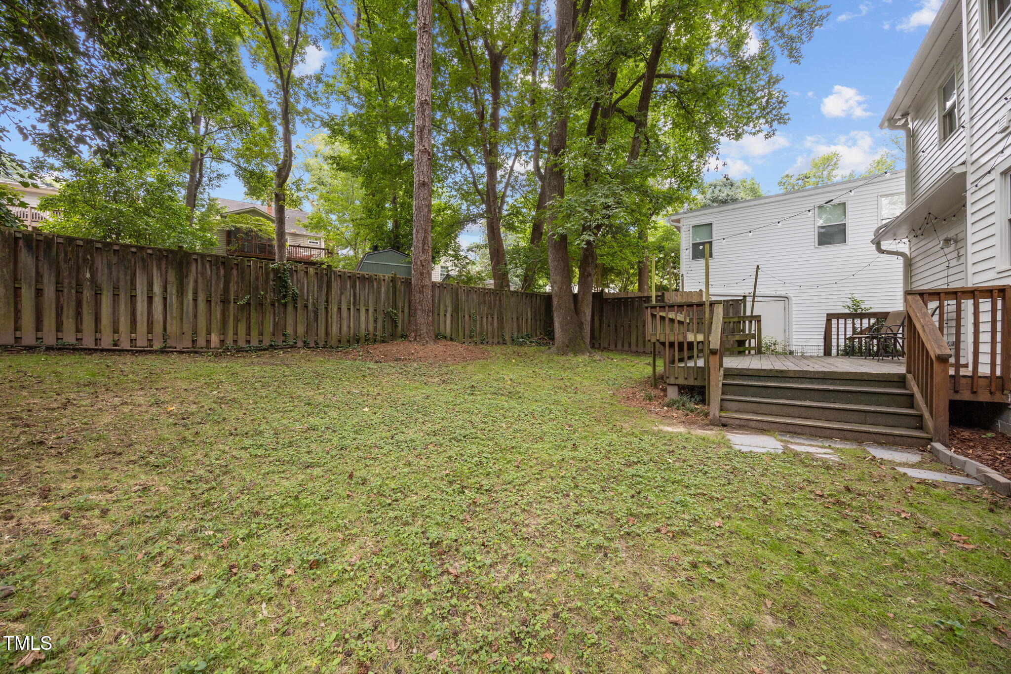 2721 Cartier Drive Raleigh, NC 27608 - Photo 35 of 44 a view of a backyard with wooden fence and a large tree