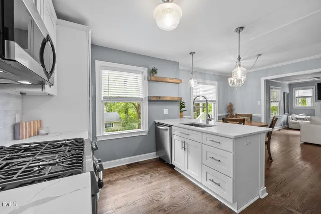 a kitchen with kitchen island granite countertop a stove a sink and a refrigerator
