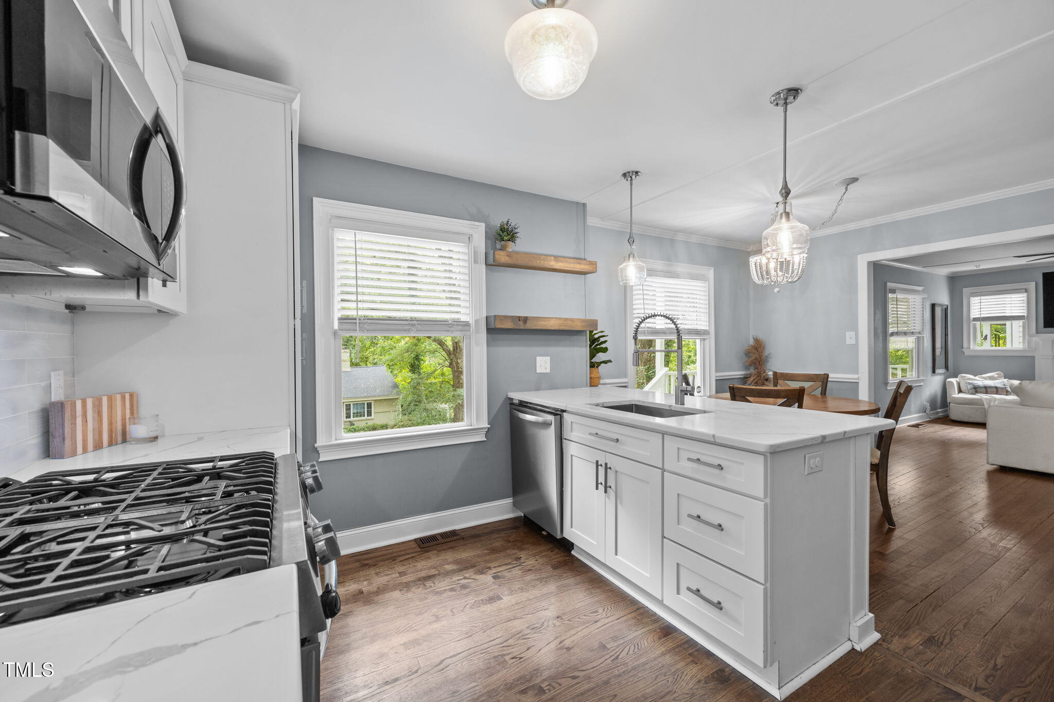 2721 Cartier Drive Raleigh, NC 27608 - Photo 6 of 44 a kitchen with kitchen island granite countertop a stove a sink and a refrigerator