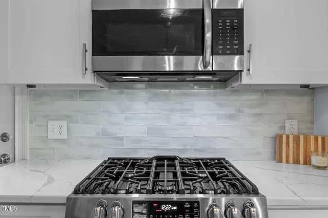 a kitchen with granite countertop a stove and a microwave
