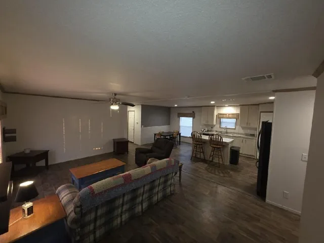 a living room with furniture a dining table and chairs with wooden floor