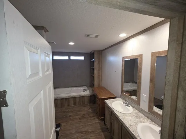 a bathroom with a double vanity sink toilet and mirror