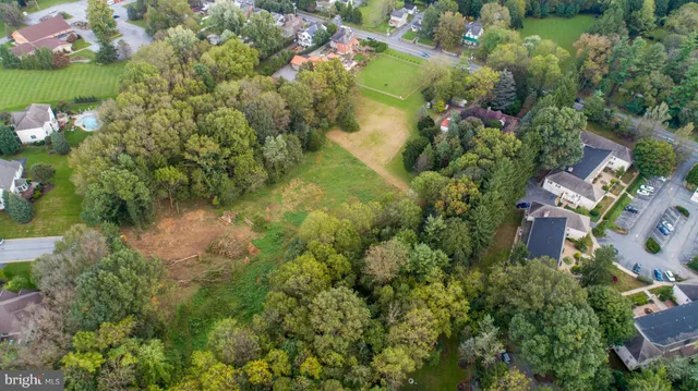 an aerial view of residential houses with outdoor space and trees