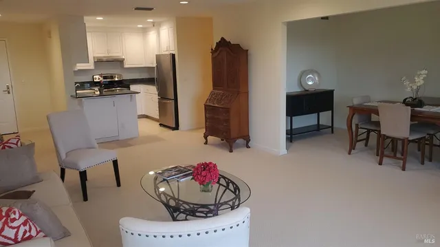 a kitchen with stainless steel appliances kitchen island granite countertop a refrigerator and a stove