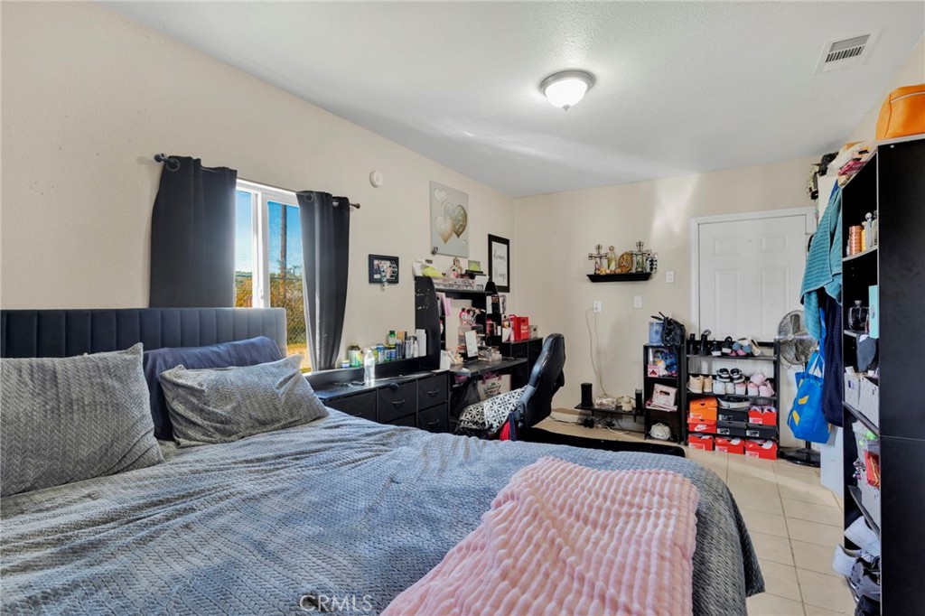 25466 Jasper Road Barstow, CA 92311 - Photo 16 of 22 a bedroom with furniture a flat screen tv and a bed