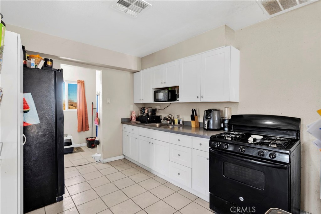25466 Jasper Road Barstow, CA 92311 - Photo 8 of 22 a kitchen with stainless steel appliances a stove a refrigerator and a sink
