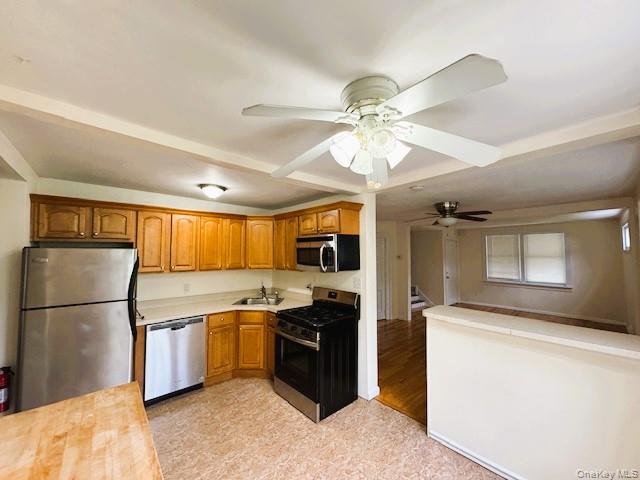 42 Hamilton Road, Unit LEFT North Merrick, NY 11566 - Photo 6 of 24 Eat-in-Kitchen Featuring wood cabinetry, Stainless Steel Appliances, corner sink, Middle Island for Four and a ceiling fan