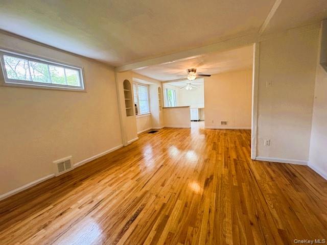42 Hamilton Road, Unit LEFT North Merrick, NY 11566 - Photo 10 of 24 Hardwood flooring throughout a spacious room with Built-in shelving, a large horizontal Window, and a Dining Room