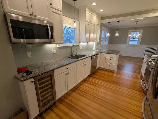 a kitchen with stainless steel appliances granite countertop a sink a stove and a microwave