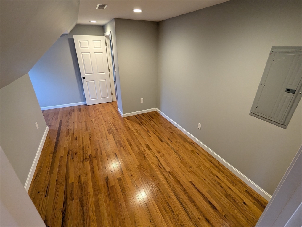 185 Mystic Street, Unit 2 Arlington, MA 02474 - Photo 15 of 33 an empty room with wooden floor and windows