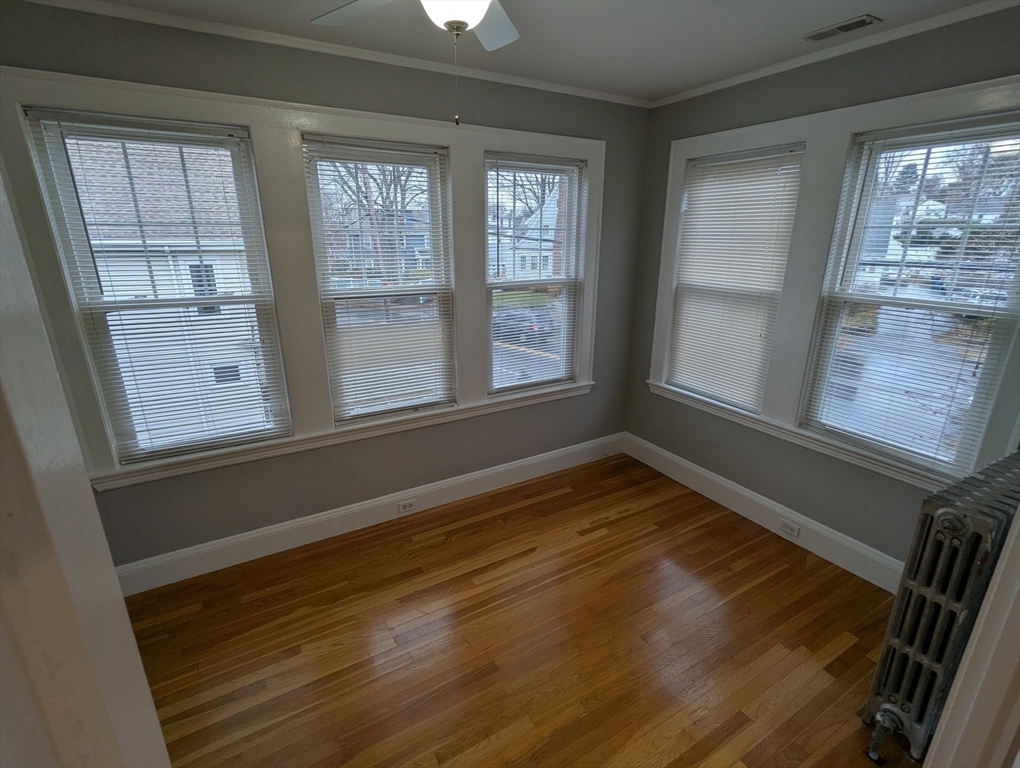 185 Mystic Street, Unit 2 Arlington, MA 02474 - Photo 21 of 33 a view of an empty room with wooden floor and a window