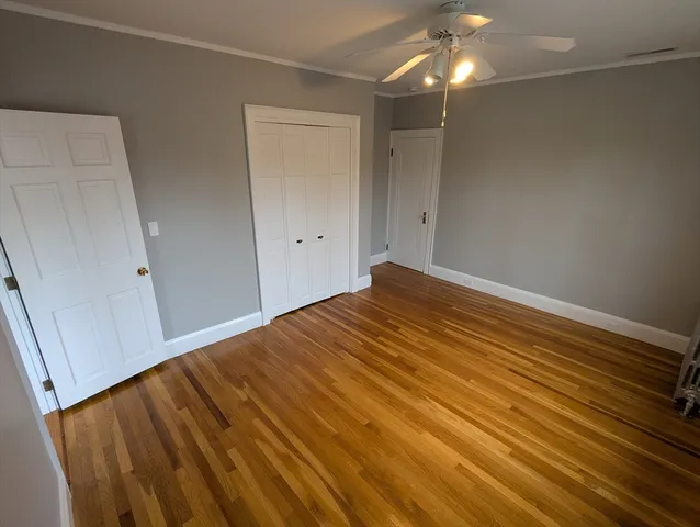 a view of empty room with wooden floor