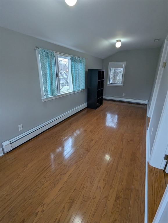 185 Mystic Street, Unit 2 Arlington, MA 02474 - Photo 27 of 33 a view of an empty room with a window and wooden floor