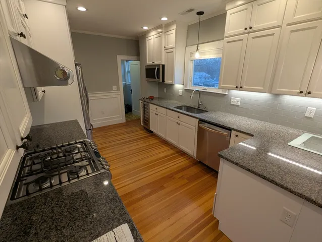 a kitchen with stainless steel appliances granite countertop a sink stove and refrigerator