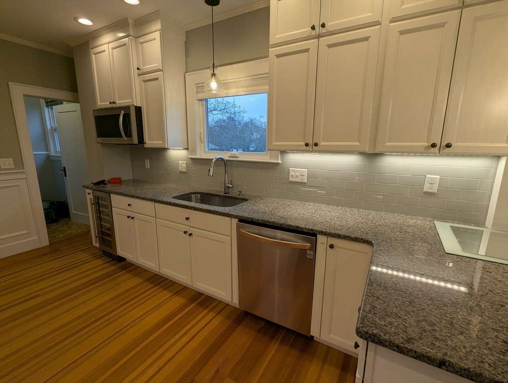 185 Mystic Street, Unit 2 Arlington, MA 02474 - Photo 5 of 33 a kitchen with stainless steel appliances granite countertop a sink a stove counter space and cabinets