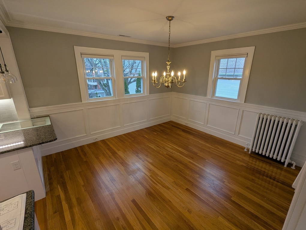 185 Mystic Street, Unit 2 Arlington, MA 02474 - Photo 6 of 33 a view of an empty room with window and wooden floor