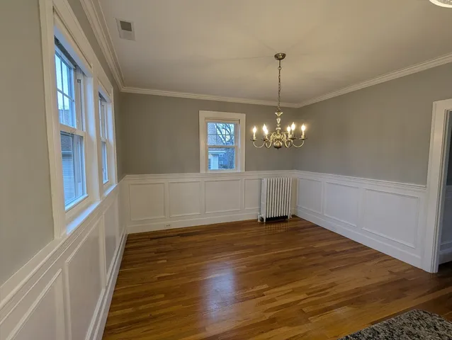 a view of a room with wooden floor chandelier and entryway
