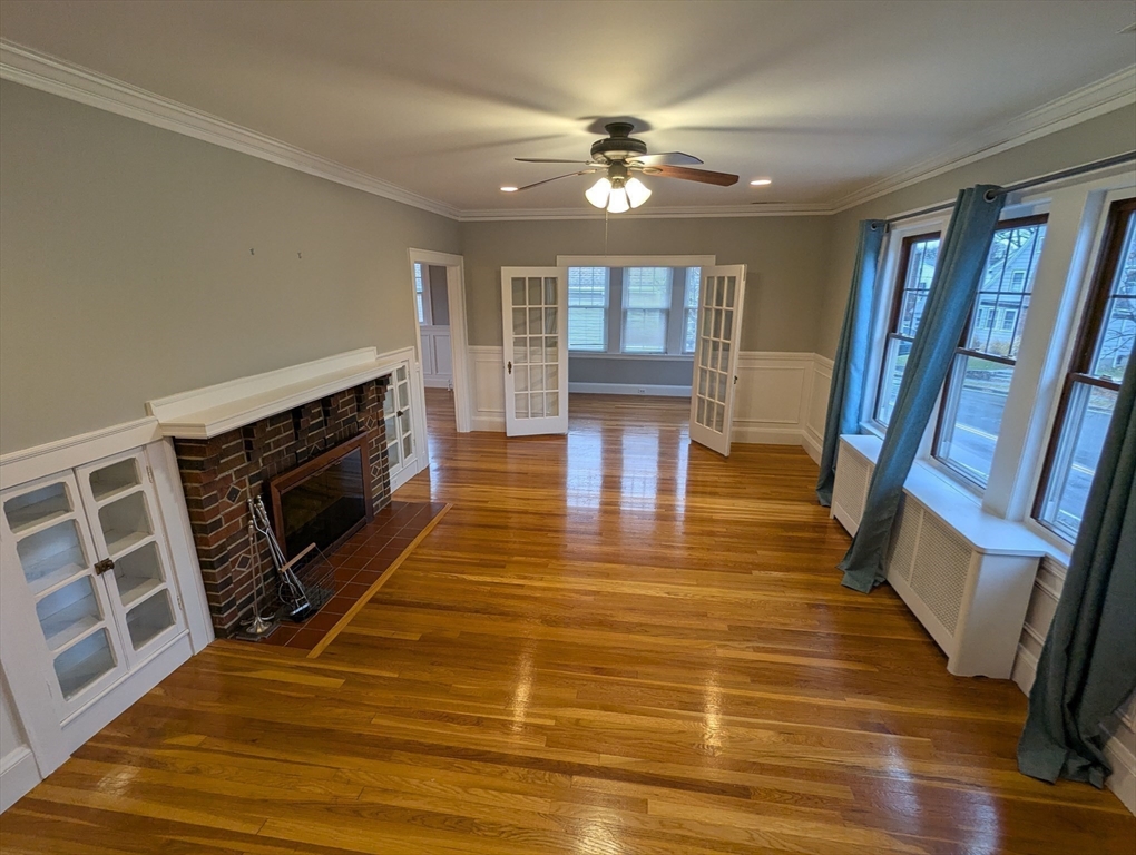 185 Mystic Street, Unit 2 Arlington, MA 02474 - Photo 8 of 33 a view of a livingroom with wooden floor and a fireplace