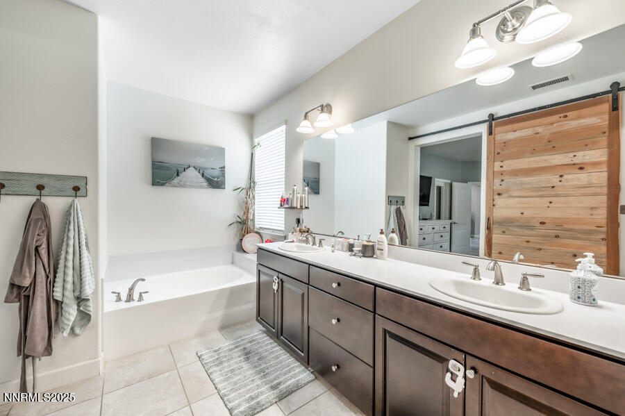 2745 Trail Rider Drive Reno, NV 89521 - Photo 26 of 50 a bathroom with a tub a sink double vanity and mirror