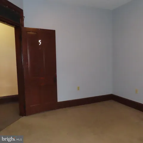 a view of an empty room with closet and a window