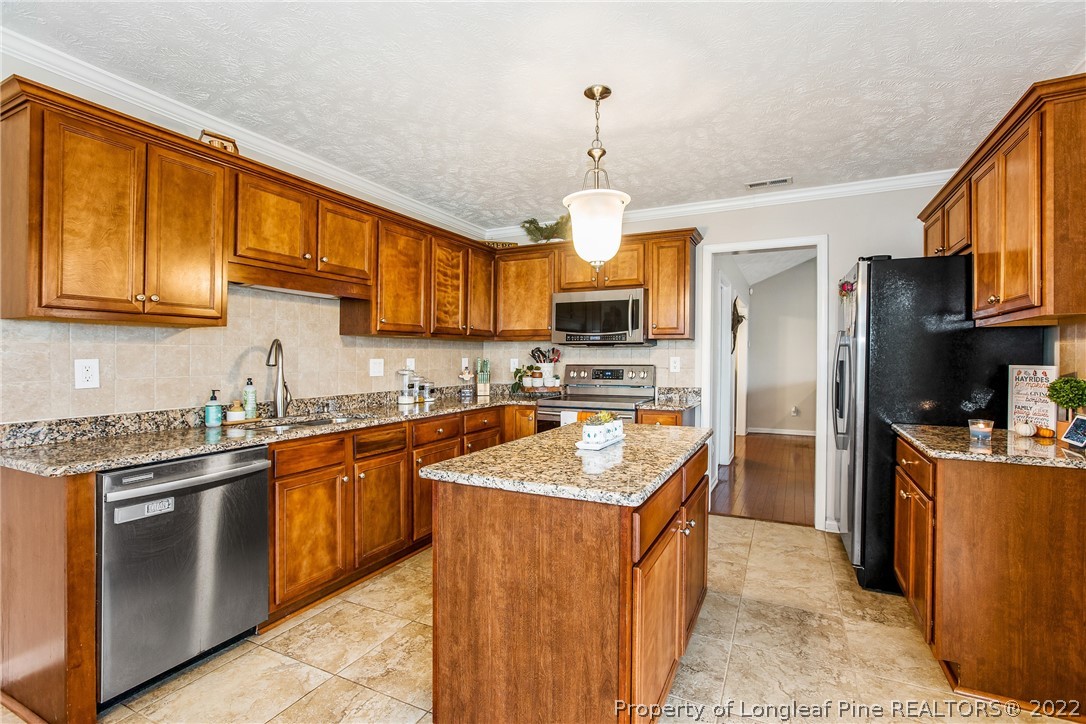 1909 Yellowbrick Road Fayetteville, NC 28314 - Photo 14 of 25 a kitchen with stainless steel appliances granite countertop a sink stove and refrigerator