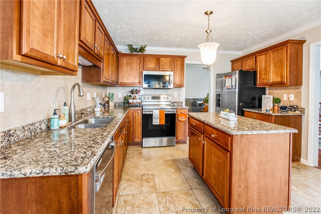 1909 Yellowbrick Road Fayetteville, NC 28314 - Photo 15 of 25 a large kitchen with stainless steel appliances granite countertop a stove a sink and a refrigerator
