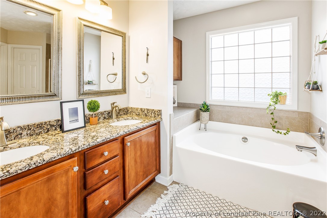 1909 Yellowbrick Road Fayetteville, NC 28314 - Photo 22 of 25 a bathroom with a tub a sink and a large mirror