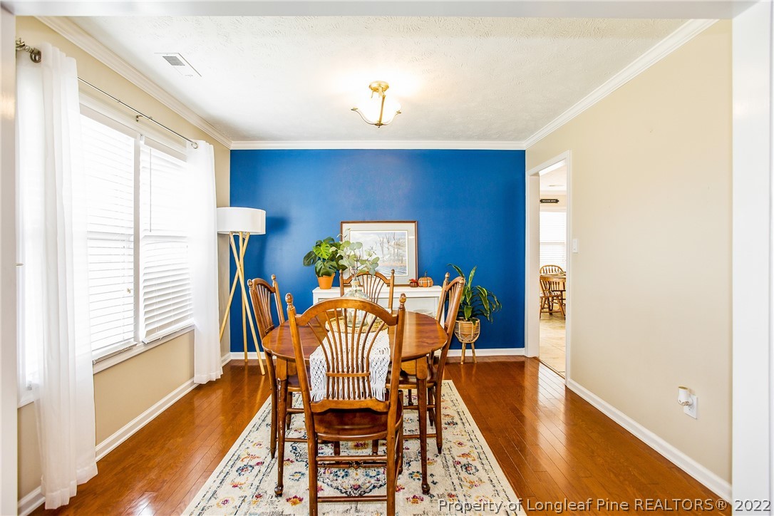 1909 Yellowbrick Road Fayetteville, NC 28314 - Photo 9 of 25 a view of a dining room with furniture a chandelier and wooden floor