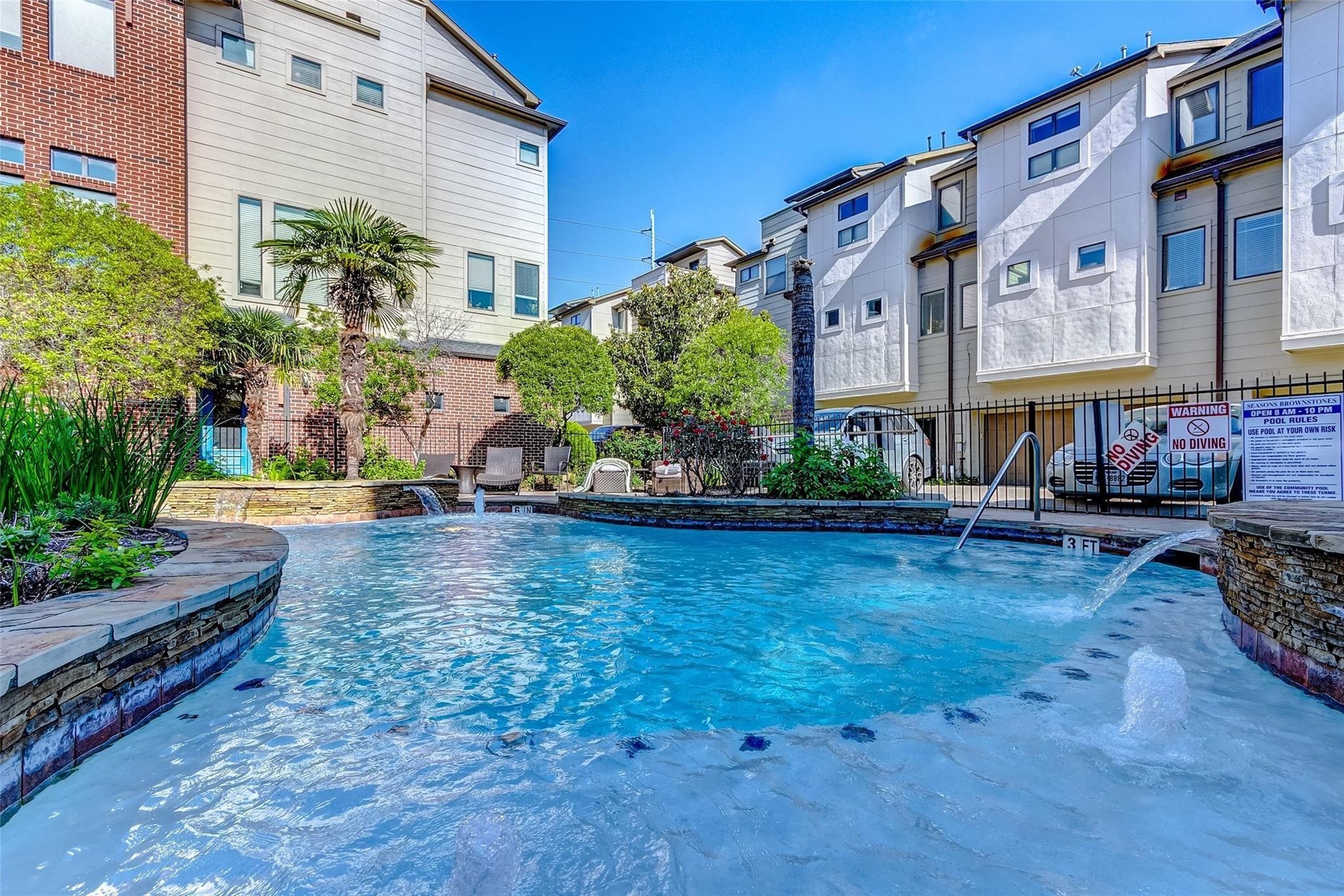 Experience a serene escape with this beautifully landscaped community pool area. Surrounded by lush greenery and lounge chairs, the sparkling pool features elegant water fountains and a shallow wading area, perfect for relaxation. Enjoy the tranquil, resort-like ambiance right outside your door.