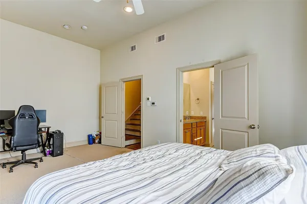 a bedroom with a bed and a flat tv screen on dresser